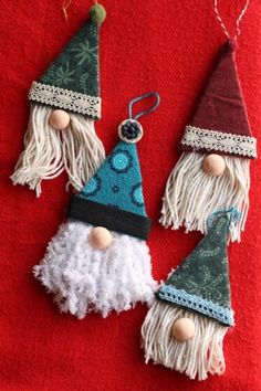 three gnome ornaments hanging on a red towel