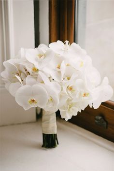 a bouquet of white flowers in front of a mirror