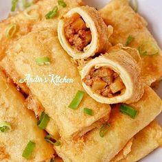 some food is on a white plate and has green onions in the top corner, along with other foods