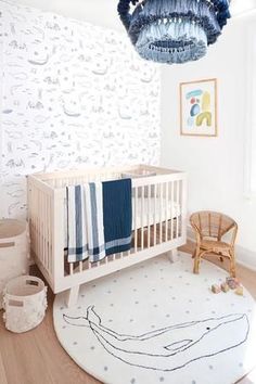 a baby's room with a white crib and blue wallpaper on the walls