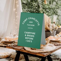 a sign that says camp charlotte next to a table with plates and glasses on it