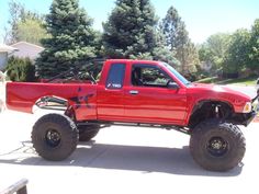 a large red truck parked on top of a driveway