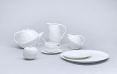 a white table setting with cups and saucers