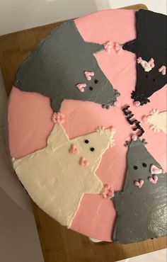 a cake that has been decorated to look like cats and mice on the side, sitting on a table