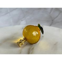 an orange shaped object sitting on top of a white marble table next to a light