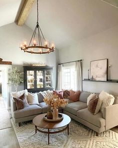 a living room filled with furniture and a chandelier hanging over the top of it