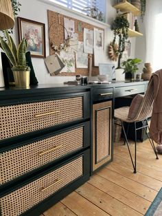 a room with wooden flooring and lots of pictures on the wall behind the desk