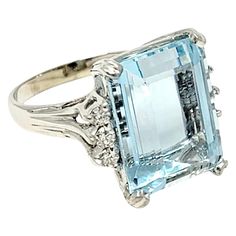 Ring size: 7.25 Breathtaking aquamarine and diamond cocktail ring. This eye-catching piece makes a bold statement with both its impressive size and exquisite color. The incredible 14.53 carat emerald cut aquamarine stone is 4 prong set in 18 karat white gold and arranged in a vertical layout. Flanking the dreamy, light blue colored stone are 6 sparkling round accent diamonds, G-H in color and SI1-SI2 in clarity, adding additional sparkle to the already remarkable piece. This ring also sits high 5 Carat Diamond Ring, Aquamarine Cocktail Ring, Platinum Diamond Engagement Rings, Diamond Cocktail Ring, Platinum Diamond Rings, Gold Cocktail Ring, Diamond Cocktail Rings, Alternative Engagement Rings, Aquamarine Stone