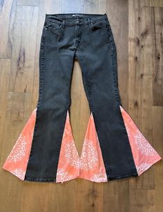 Take your denim game to the next level with these upcycled black Levi's straight-leg jeans, now transformed into stunning bell-bottoms. Featuring peach bandana print inserts, these jeans offer a bold pop of color and a unique retro twist to your wardrobe. Handcrafted with love and sustainability in mind, these bell-bottoms combine vintage inspiration with a modern boho-chic vibe. These jeans are a size 12 with a 32-inch inseam and a 41 1/2-inch outseam, perfect for those who love classic Levi's quality with an artistic upgrade. Whether you're headed to a festival or just looking to add some retro flair to your everyday wear, these one-of-a-kind jeans are made for you. Details: Size: 12 (Levi's straight-leg, upcycled) Color: Black with peach bandana print fabric inserts Material: Denim with Cotton Fitted Flare Jeans For Festivals, Black Cotton Flare Jeans For Summer, Fitted Cotton Flare Jeans For Festivals, Cotton Flare Jeans With Wide Leg For Festival, Cotton Wide Leg Flare Jeans For Festival, Cotton Bohemian Flare Jeans, Bohemian Cotton Flare Jeans, Bohemian Flare Cotton Jeans, Levis Straight Leg Jeans