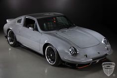 a gray sports car parked in a dark room