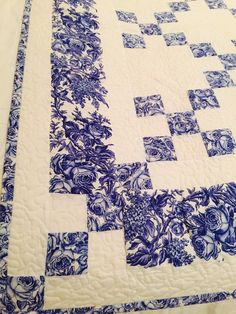 a blue and white quilt with flowers on it