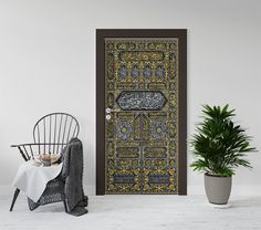 a chair and potted plant sit in front of a door decorated with intricate designs