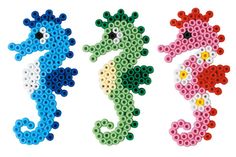 three seahorses made out of perler beads are shown in different colors and sizes