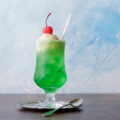 a green and white drink with a cherry on top