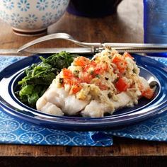 a blue plate topped with fish and vegetables