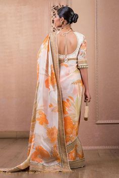 Sunset floral-printed saree in satin-organza fabric with multi-colour hand-embroidered borders, uplifted with pearl hangings. Paired with a textured hand-embroidered tulle blouse.
Components: 2
Pattern: Embroidered,Printed
Type Of Work: Floral
Neckline: Scoop
Sleeve Type: Elbow
Fabric: Blouse : Tulle, Saree : Satin Organza
Color: Orange
Other Details: 
Back tassel tie-up
Tassel pallu
Note: Bag shown in the video and images is not for sale
Occasion: Wedding,Bride - Aza Fashions Tulle Saree, Saree Satin, Tulle Blouse, Floral Print Sarees, Print Saree, Tarun Tahiliani, Orange Blouse, Printed Saree, Embroidered Tulle