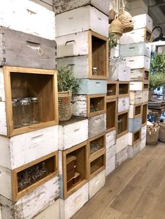 several wooden shelves filled with lots of different kinds of boxes and baskets on top of each other