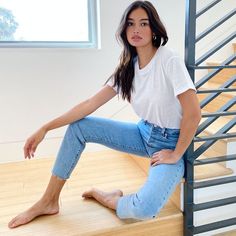 a woman is sitting on the stairs with her legs crossed