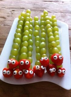 grapes and strawberries are arranged in the shape of eyeballs on a white platter