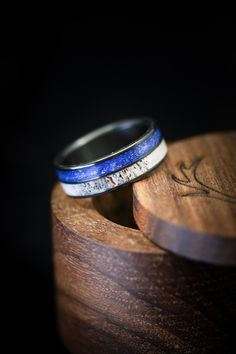 two rings sitting on top of a wooden box with writing on it's sides