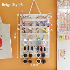 a wall mounted jewelry rack next to a canvas bag and an orange wall behind it