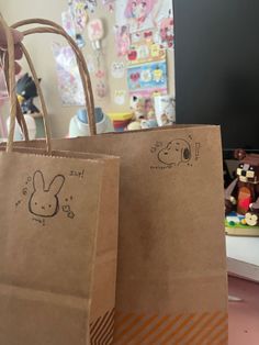 two brown paper bags sitting on top of a table next to a stuffed animal toy