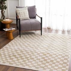 a living room area with a chair, coffee table and rug on the hardwood floor