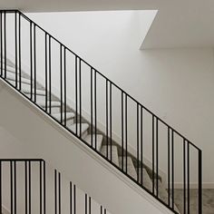 an empty staircase with black railings and white walls