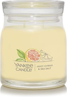 yankee candle jar with grapefruit and sea salt in front of the lid on a white background