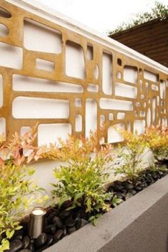 an outdoor wall with plants and rocks on it