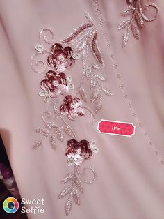 a pink dress with silver sequins and flowers on the front, along with a red tag that says sweet saffre