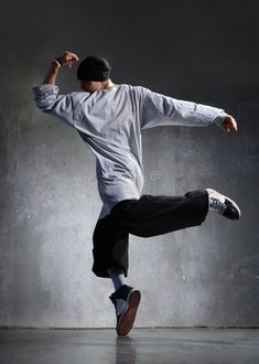 a man in white shirt and black pants doing a kick