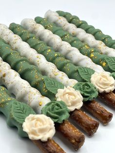 there are many green and white desserts with flowers on them in the shape of sticks