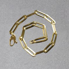 This simple yet dramatic bracelet combines the timeless shine of 14K yellow gold and the modern geometry of paperclip chain links. Bracelet is 7 1/2 inches long, 4.2mm wide, and closes with a lobster clasp.Product Details: Bracelet Information : Metal : 14K Yellow Gold Chain Type : Link Clasp : Lobster Clasp Width : 0.17 in Approximate Weight: Size Weight 7.5'' 2.5 grams Men Shoes Formal, Silver Jewelry Necklace, Zircon Jewelry, Sneaker Jewelry, Chain Links, Yellow Gold Chain, Diamond Pendant Necklace, Gold Diamond Rings, Mens Slippers