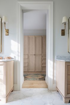 an image of a bathroom setting with wood cabinets and marble counter tops on the floor