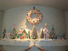 a mantle with christmas decorations and wreaths on it