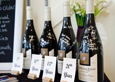 several bottles of wine sitting on top of a table with price tags in front of them