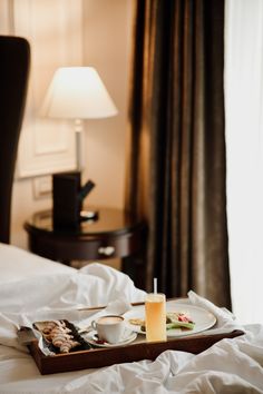 a tray with food on top of a bed