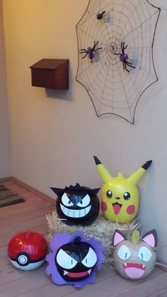 several pokemon masks sitting on top of a wooden table next to a spider web net