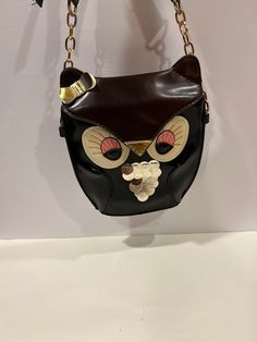 "Elevate your accessory game with our Vintage Ibiza Yenzi Small Owl Purse. This adorable crossbody bag, crafted from faux leather, combines fashion and fun seamlessly. Carry your essentials in style with this unique and charming animal-themed shoulder purse. Condition: Vintage Excellent Measurement's : 25\" High With Strap 7.5\" Wide 8\" Long 2\" Bottom  Sold as is Review all pictures closely. Most of my items are vintage and used, they will all show some signs of light wear or use. Major flaws will be noted in the description. Items are sold \"as is\" so please make sure you look at all pictures carefully. I have done my best to capture color and size. I am not an expert on vintage items but I do my best to describe items I have listed. Any props in the pictures are not included." Novelty Black Bag For Gift, Cute Black Shoulder Bag For Party, Black Animal Design Satchel Bag, Cute Gold Bags For Everyday Use, Cute Black Leather Bag, Black Novelty Bag For Everyday Use, Novelty Pouch Bags For Everyday Use, Vintage Ibiza, Owl Purse