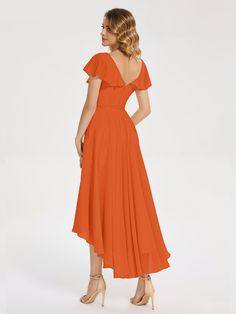 a woman is wearing an orange dress and heels