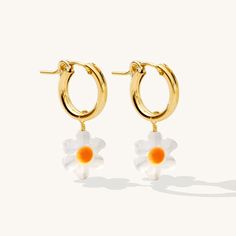 If you love all things adorable and floral, these dainty earrings are for you! The Daisy Hoop Earrings feature a delicate daisy bead made of Mother of Pearl, perfect for spring and summer! These pretty earrings are sure to catch attention. Complete the look with our Daisy Necklace. DETAILS 14k gold filled 13mm hoops and wire 10mm Mother of Pearl daisy charms Comes as a pair Safe for sensitive skin & shower safe Matching necklace: Daisy Necklace Daisy Charm, Daisy Necklace, Pretty Earrings, Dainty Earrings, Matching Necklaces, How To Make Beads, Mother Of Pearl, Sensitive Skin, Gold Earrings