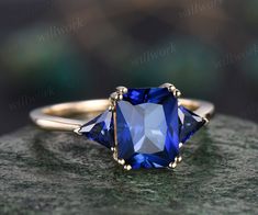 a blue stone ring sitting on top of a rock