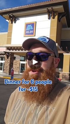 a man with a beard and sunglasses standing in front of a building that says dinner for 8 people for $ 15