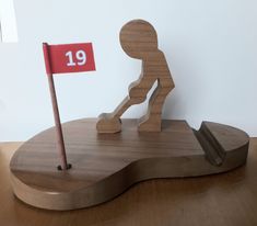 a wooden figure holding a red flag on top of a wooden base with the number 19