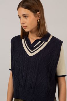 Get your preppy look on point with our navy and ivory varsity sweater vest. This lightweight yet cosy knitted vest is perfect to layer over a blue or ivory blouse. Its classic V-neck and cable-knit texture give a preppy vibe while the side slits serve as an original detail. This vegan-friendly knit will keep you warm while looking sharp. - Navy and ivory varsity vest - Cable-knit - Vegan-friendly knitwear Navy Cotton Cable Knit Top, Navy Cable Knit Cotton Top, Cotton Cable Knit Sweater Vest For Layering, Cable Knit Cotton Sweater Vest For Layering, Cotton Cable Knit V-neck Sweater Vest, Navy Cable Knit Top, Classic Cotton Cable Knit Sweater Vest, Argyle Sweater Vest, Ivory Blouse