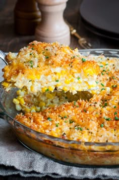 a casserole dish filled with corn and topped with a serving utensil