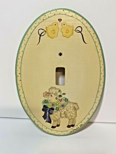 a decorative light switch plate with two sheep on it's side and flowers in the middle