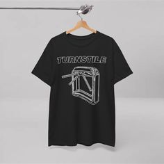 a black t - shirt with the words turnstile on it hanging from a hanger