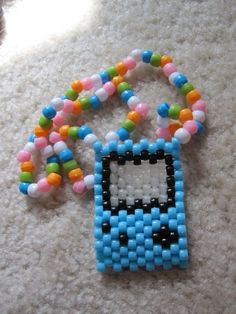 a beaded cell phone charm is laying on the floor